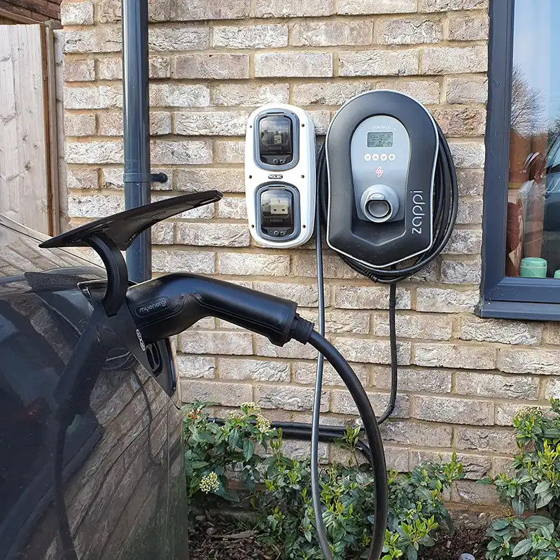 An EV charger installation charging a car on a property's driveway